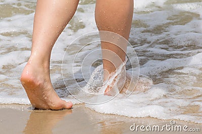 Two feet walking through the waves Stock Photo