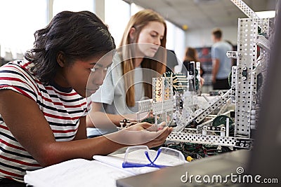 Two Female College Students Building Machine In Science Robotics Or Engineering Class Stock Photo