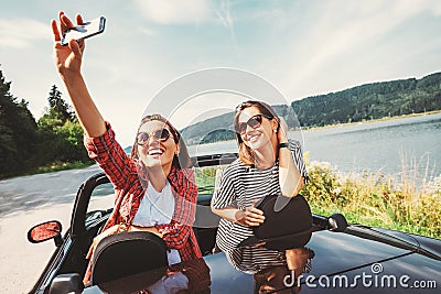 Two female freinds take a selfie photo during their auto travel Stock Photo