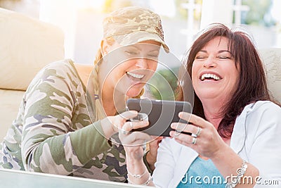 Two Female Friends Laugh While Using A Smart Phone Stock Photo