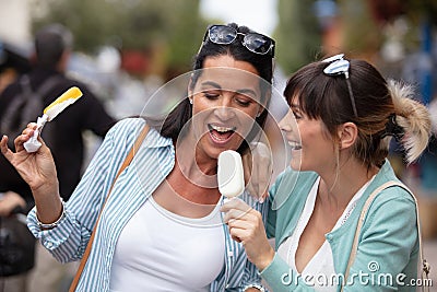 two female friends licking ice cream Stock Photo