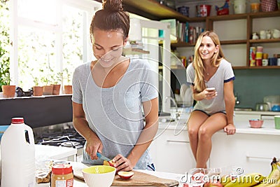 Two Female Friends Preparing Breakfast At Home Together Stock Photo