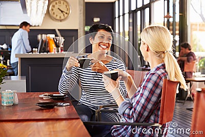 Two female friends talking at a coffee shop Stock Photo