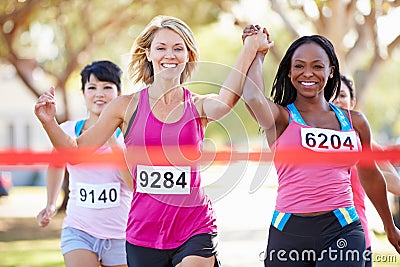 Two Female Runners Finishing Race Together Stock Photo