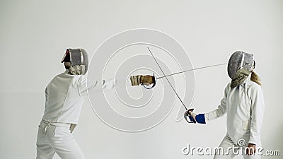 Two fencers having break after training attack exercises in fencing in studio indoors Stock Photo