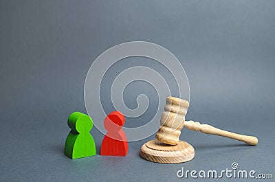 Two figures of people opponents stand near the judge`s gavel. Conflict resolution in court, claimant and respondent. Court case Stock Photo