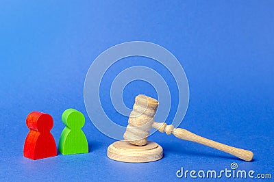 Two figures of people opponents stand near the judge`s gavel. The judicial system. Court case, settling disputes. Legal advice Stock Photo