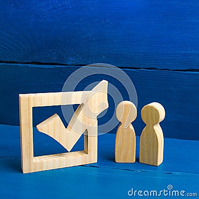 Two figures stand together next to tick in the box. The concept of elections and social technologies. Volunteers, parties Stock Photo