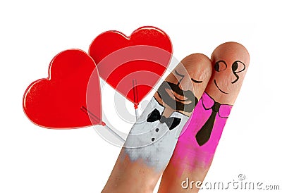 Two fingers with cartoon man face painted as happy and free homosexual couple celebrating Valentines day or getting married and Stock Photo