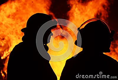 Two fire fighter men rescue workers at night blaze Stock Photo
