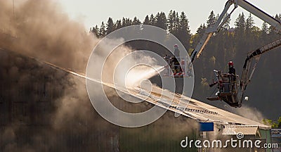 Two firemen fighting a warehouse fire Stock Photo