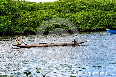 Two fishermen in a canoe navigating the Jaguaripe River Editorial Stock Photo