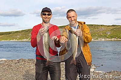 Two fishermen hold a huge graylings. Stock Photo