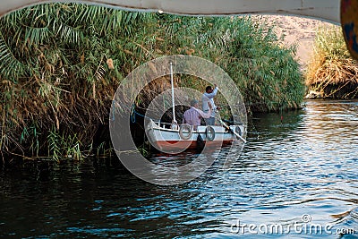 Two friendly fishermen who are greeting us from their small boat on the Nile river Editorial Stock Photo