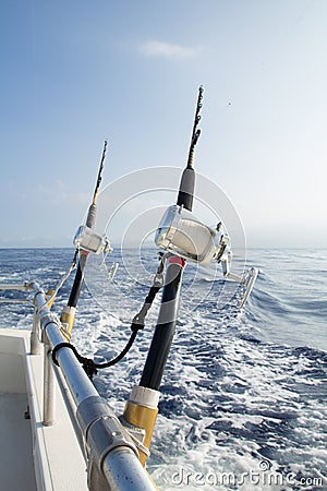 Two fishing rigs tethered to rail Stock Photo