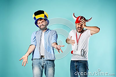 The two football fans with mouthpiece over blue Stock Photo