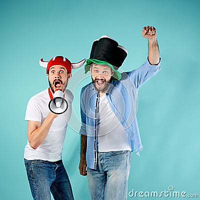 The two football fans with mouthpiece over blue Stock Photo