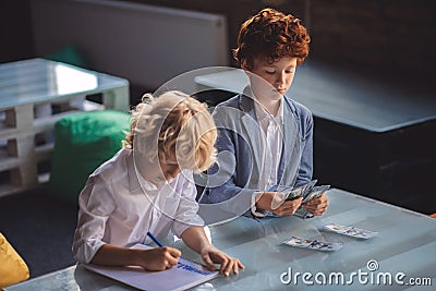 Two friends counting saved money and looking involved Stock Photo