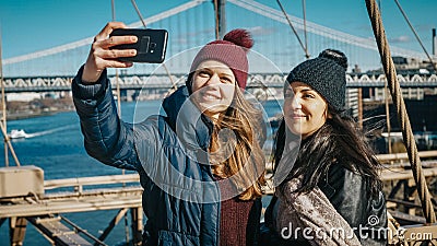 Two friends in New York walk over the famous Brooklyn Bridge Stock Photo