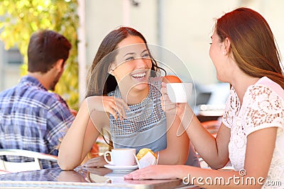 Two friends or sisters talking taking a conversation in a bar Stock Photo