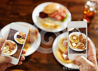 Two friends taking photo of their food with smartphones Stock Photo