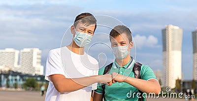 Two friends of teenagers meet in the city. They greet each other without contact . Stock Photo