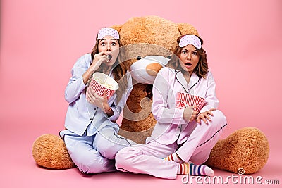 Two frightened pretty girls dressed in pajamas Stock Photo