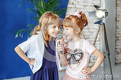 Two funny children sing a song in karaoke. The concept is childh Stock Photo