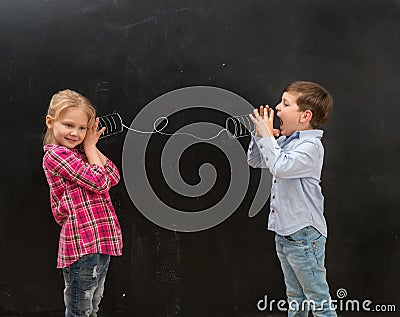 Two funny children talking on self-made drawn telephone Stock Photo