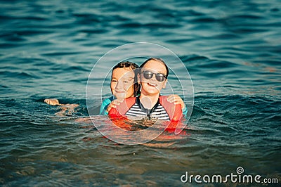 Two funny kids, little boy and teenage girl playing together in the sea Stock Photo