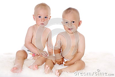 Two funny lovely baby boys sitting together on white background Stock Photo