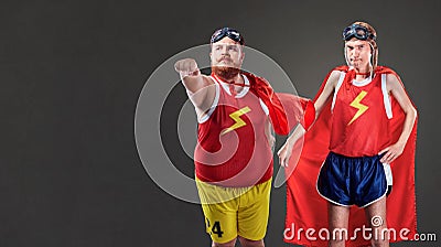 Two funny men in suits of superheroes. Thin and fat people Stock Photo