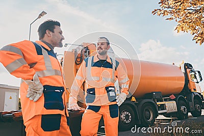 Two garbage removal service workers having short break Stock Photo