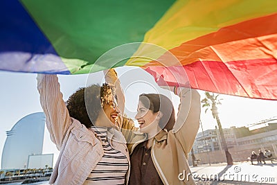 Two gay girls laughing with rainbow flag Stock Photo