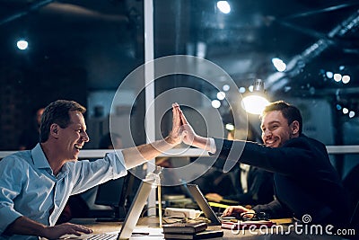 Two gentlemen staying up late in office working. Stock Photo