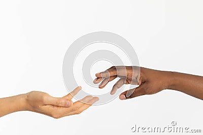 A helping hand outstretched to give support. Two hands approaching each other. Hands of two races, African and European Stock Photo