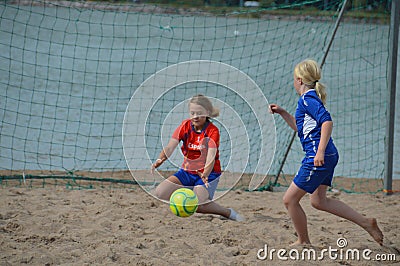 Beach football, girls playing in team outfits on the sand beach Editorial Stock Photo