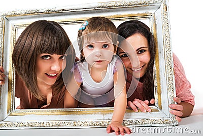 Two girls and child holding wooden white frame Stock Photo