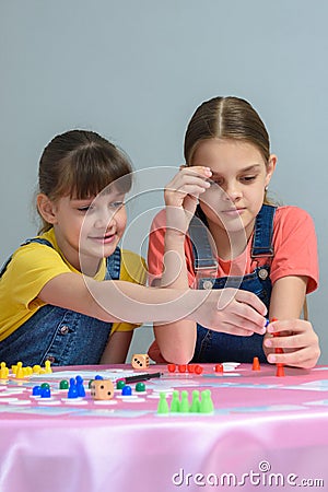 Two girls enthusiastically play a board game Stock Photo