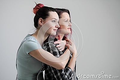 Two girls hug on a white background. Homosexual lesbian couple. Casual clothes. Stock Photo