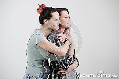 Two girls hug on a white background. Homosexual lesbian couple. Casual clothes. Stock Photo