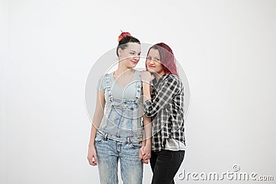 Two girls hug on a white background. Homosexual lesbian couple. Casual clothes. Stock Photo