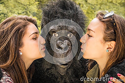 Two Girls kissing an astonished Gorilla Stock Photo