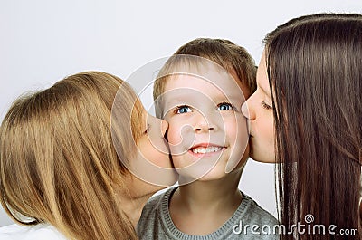 Two girls kissing little cheerful boy Stock Photo