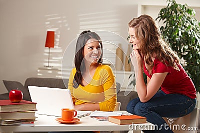 Two girls laughing together at table Stock Photo
