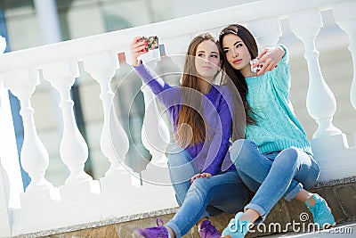 Two girls listening to music on their smartphones. Stock Photo