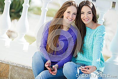 Two girls listening to music on their smartphones. Stock Photo