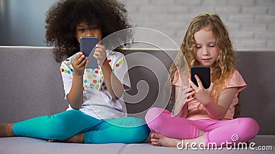 Two girls playing games on smartphones instead playing together gadget addiction Stock Photo