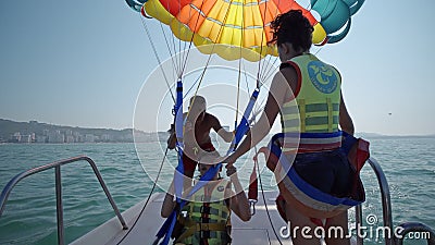 Two girls prepare for take off from boat at parasailing at Beach in Durres Editorial Stock Photo