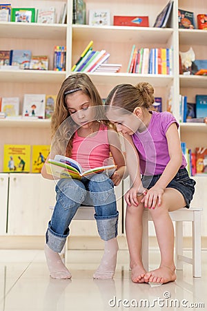 Two girls reading a fascinating book Stock Photo